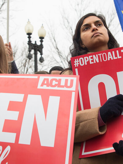 Demonstrators holding signs with the message "Open to All"