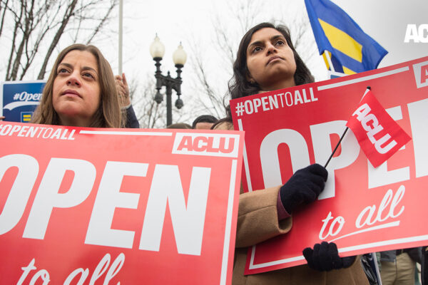 Demonstrators holding signs with the message "Open to All"