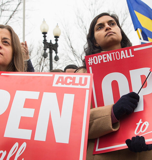 Demonstrators holding signs with the message "Open to All"