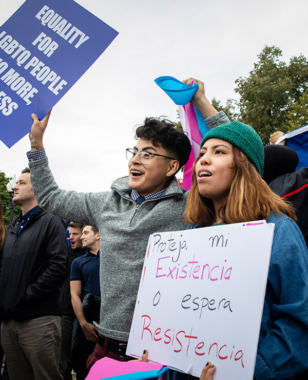 Demonstrators carrying signs advocating for the rights of LGBTQ people.
