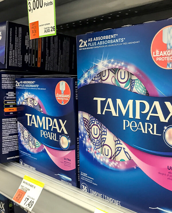 Tampax tampon boxes on the shelf in a pharmacy.