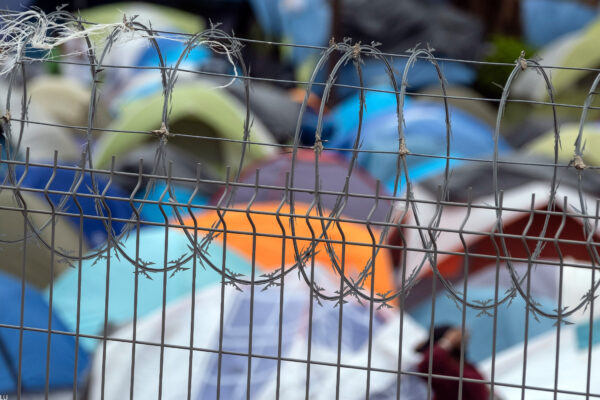 Barbed wire fence at a refugee camp for migrants and asylum seekers in Matamoros, Mexico, October 2019. Guillermo Arias for the ACLU.