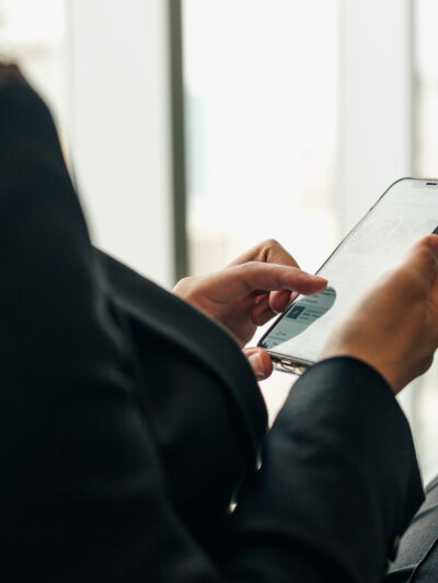 Woman holding a phone browsing Facebook