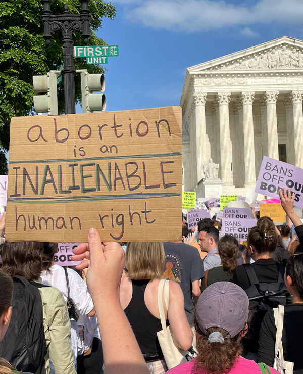 Protesters marching in Washington, DC, and carrying signs saying Abortion Is An Unalienable Human Right.