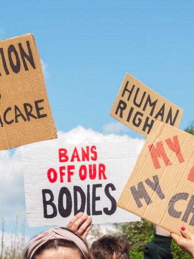 Protest signs for abortion that read "abortion is healthcare", "my body my choice," and "bans off our bodies"