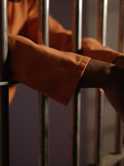 hands behing prison bars