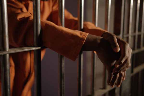 hands behing prison bars