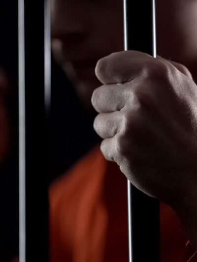 hands gripping prison bars