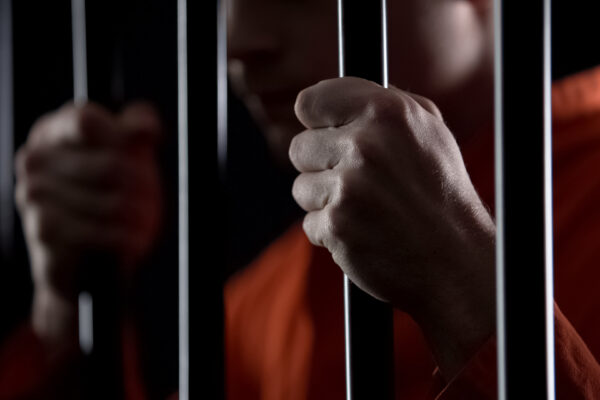 hands gripping prison bars