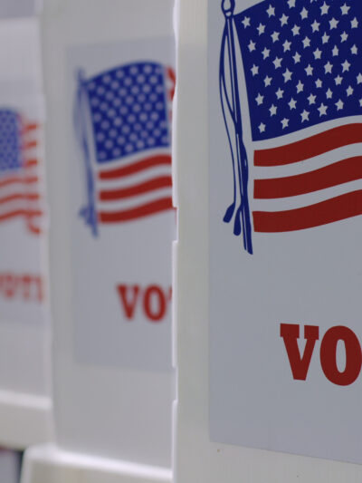 row of 4 voter boxes. On the front is the American flag and underneath in red it reads "vote."