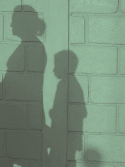 Shadow of mother and two children on a wall.