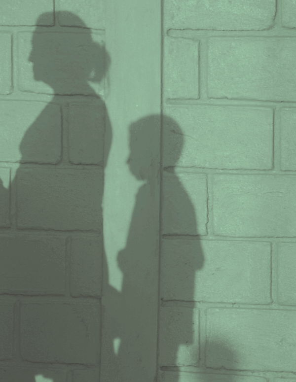 Shadow of mother and two children on a wall.
