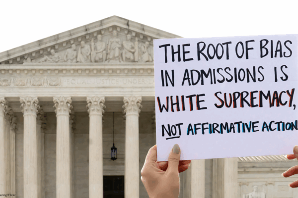 Protest sign that says "The root of bias in admissions is white supremacy, not affirmative action."