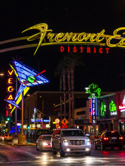 Fremont Street at night with cars driving under the overhead sign