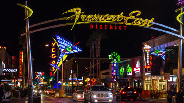 Fremont Street at night with cars driving under the overhead sign