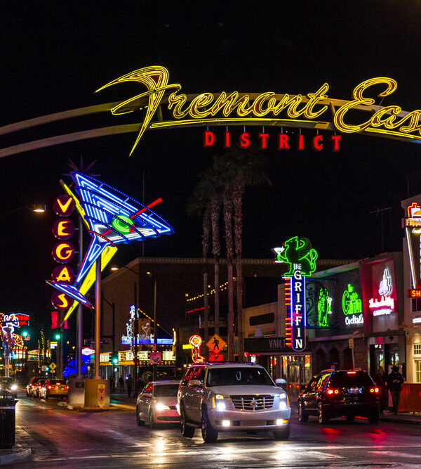 Fremont Street at night with cars driving under the overhead sign