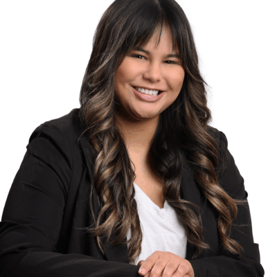 Headshot of Jordyn. She is wearing a white shirt and a black blazer. She is a brown woman with long brown hair and bangs.