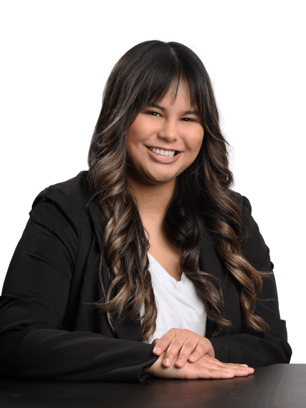 Headshot of Jordyn. She is wearing a white shirt and a black blazer. She is a brown woman with long brown hair and bangs.