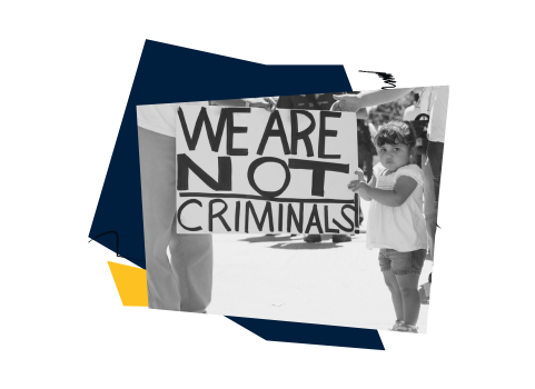 Black-and-white photo of a young child standing beside an adult holding a protest sign that reads ‘We Are Not Criminals.’ The image is framed by abstract navy and yellow geometric shapes, symbolizing immigrant rights and family unity.