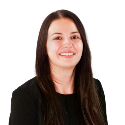 Woman with long straight brown hair, wearing a black top, smiling in front of a white background.