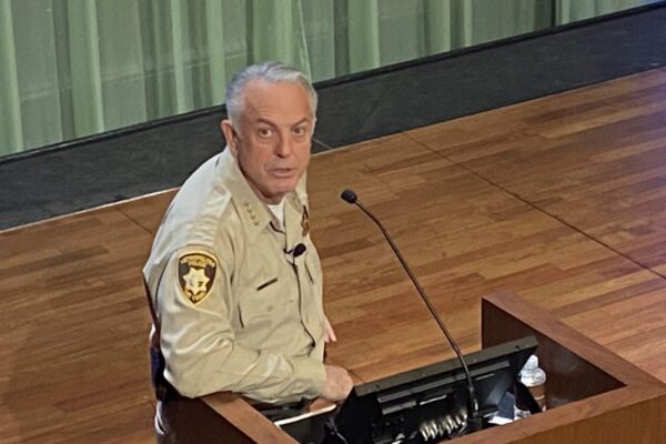 Governor Joe Lombardo at a podium looking up at the camera