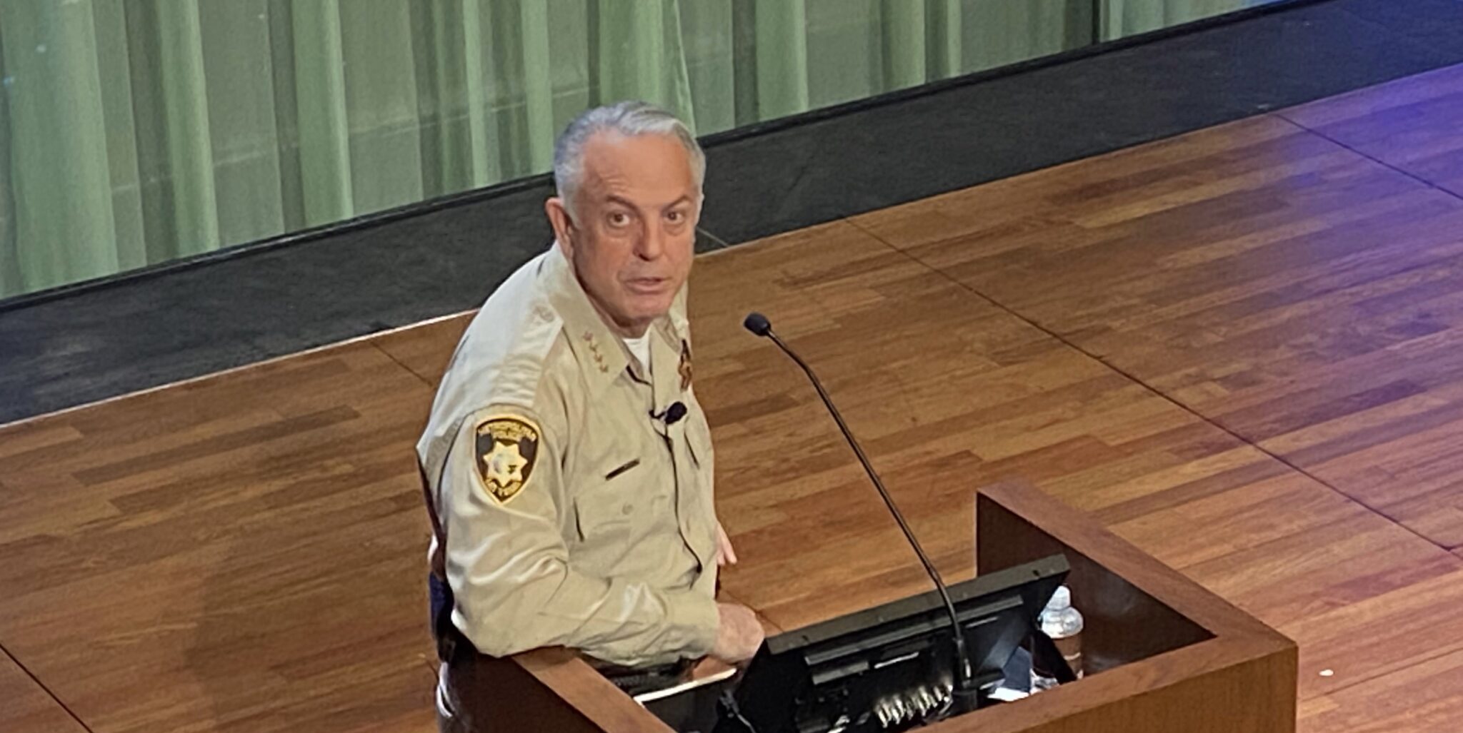 Governor Joe Lombardo at a podium looking up at the camera