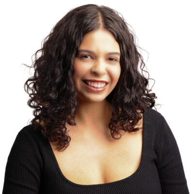 Headshot of Samantha. She is a brown woman with dark brown curly hair. She is wearing a long sleeve black top.
