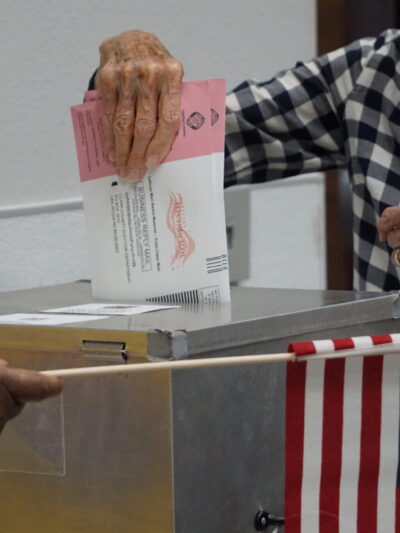 Voter placing Nevada mail ballot into drop box.