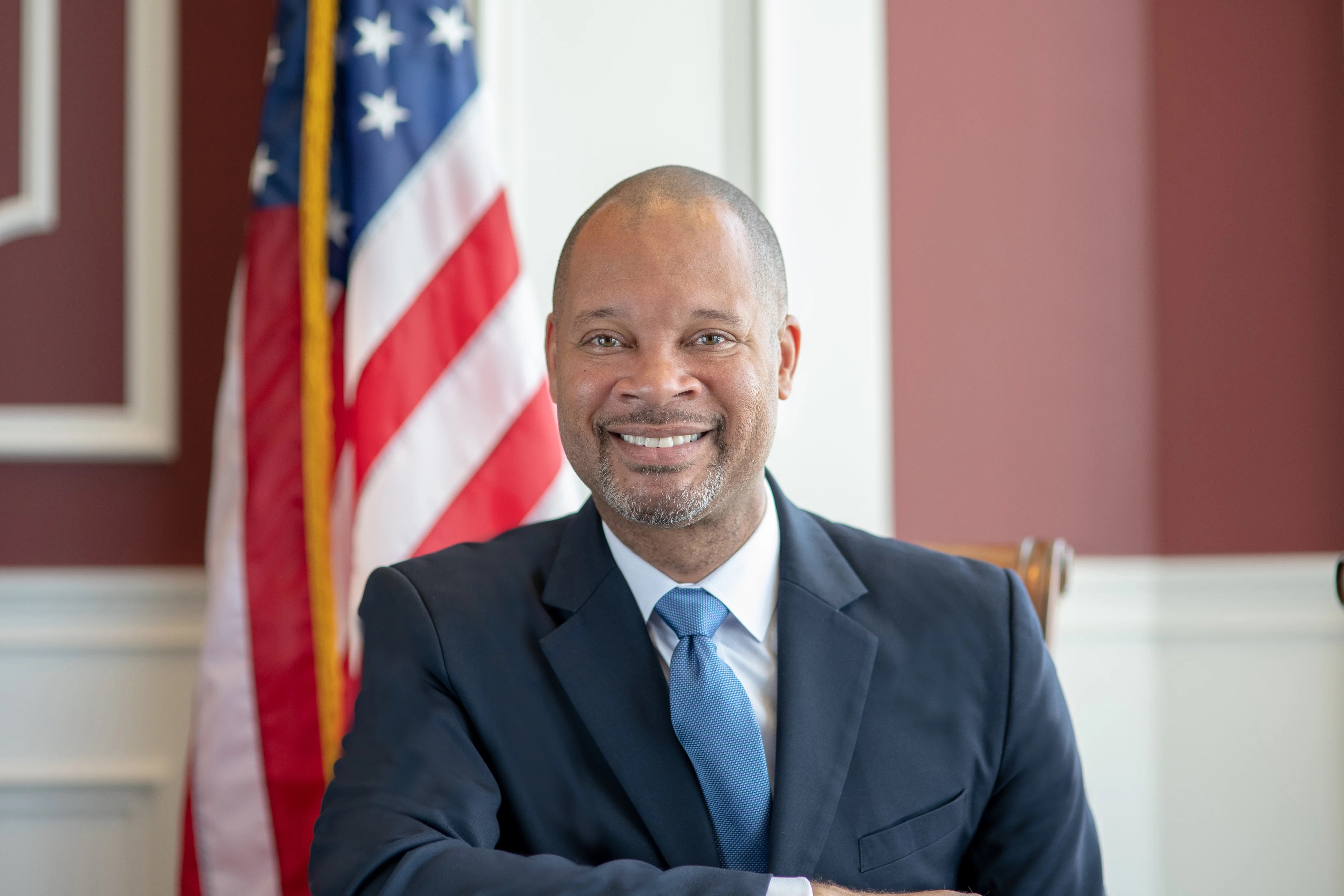 A headshot of Aaron Ford in front of the American flag.