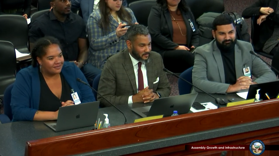 Lilith, Assemblyman Miller, and Athar sitting at a desk presenting the bill to the Assembly Committee on Growth and Infrastructure.