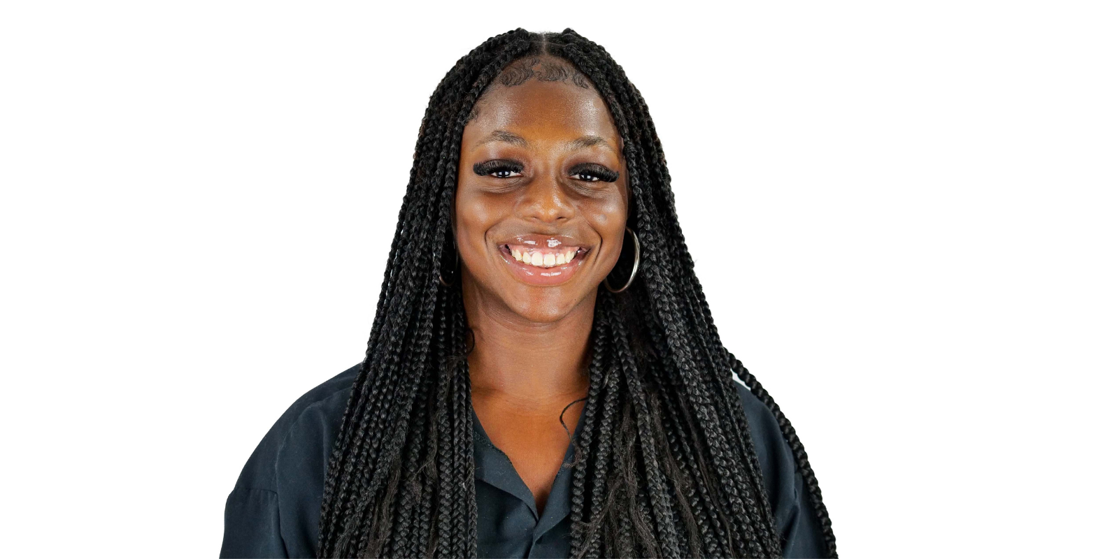 Derrica Daniel in front of a white background. She is wearing a black collared shirt.