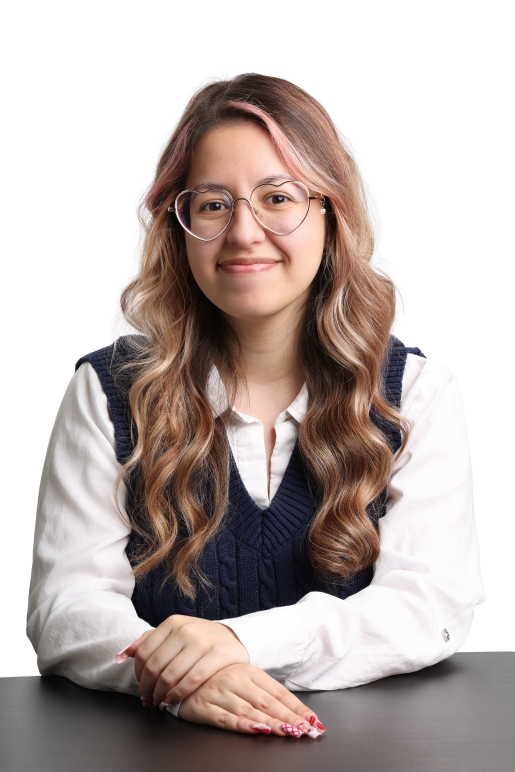 Headshot of Jessica. She has long pink and brown hair, is wearing heart shaped glasses, and a navy sweater vest with a white collared shirt underneath.