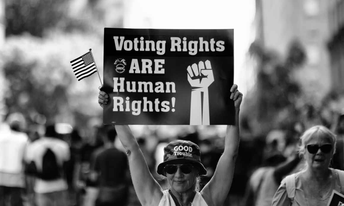 Woman holding sign that says "Voting Rights are Human Rights"