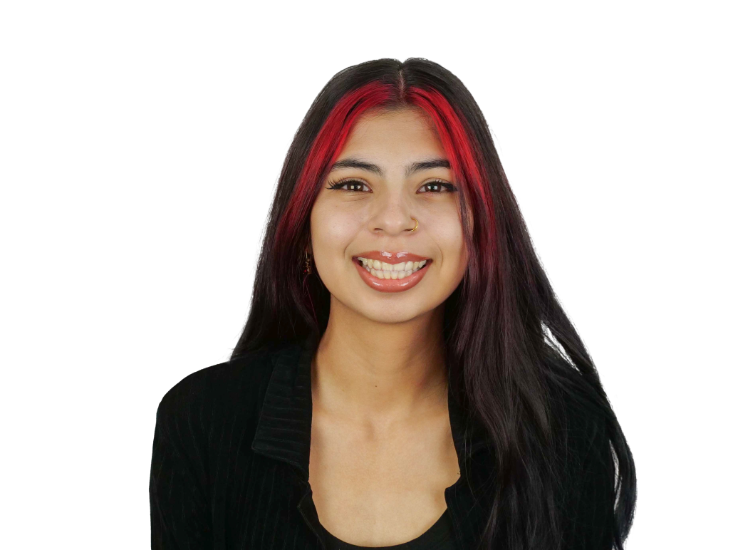 Suzanne in front of a white background. She is smiling and her hair has red face framing highlights.