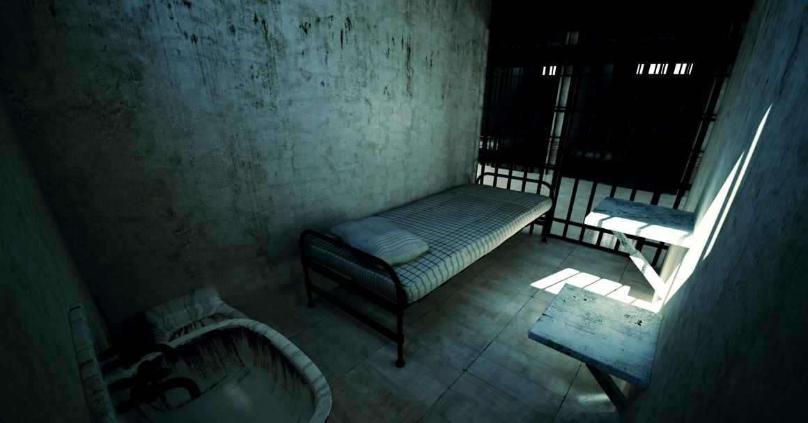 Dark prison cell with a bed and toilet