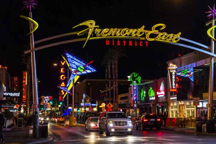 Fremont Street at night with cars driving under the overhead sign