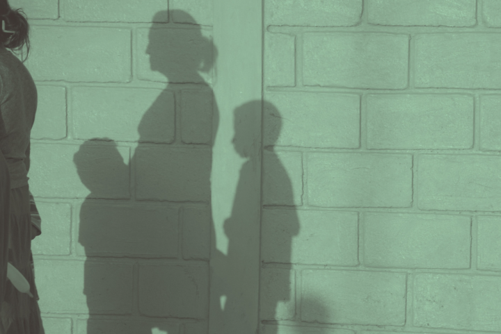 Shadow of mother and two children on a wall.
