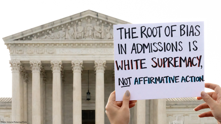 Protest sign that says "The root of bias in admissions is white supremacy, not affirmative action."