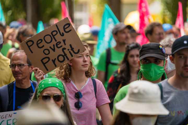 Protest sign that says "people over profit."