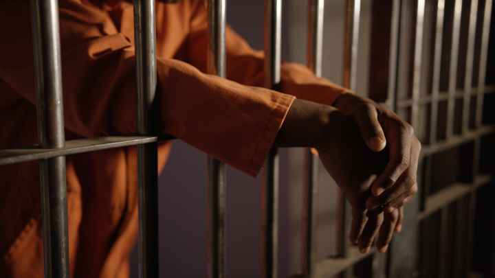 hands behing prison bars