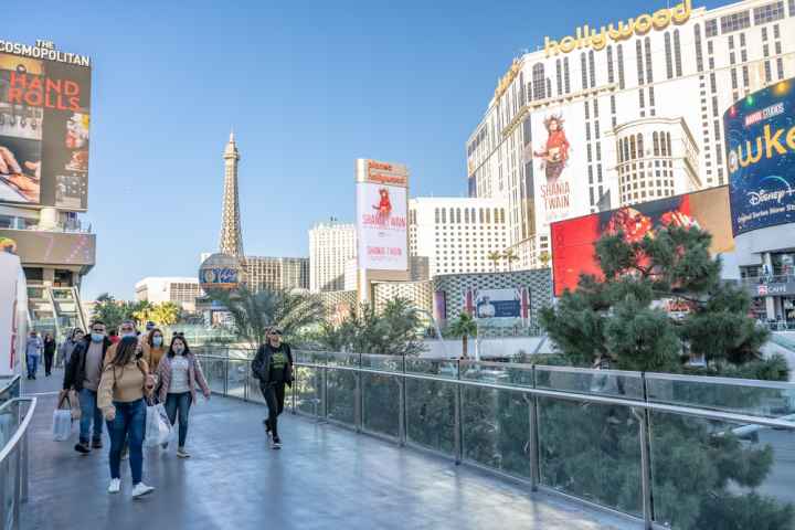 People walking on a bridge over the Las Vegas Strip.