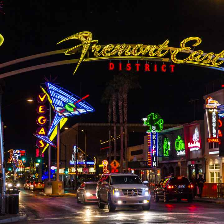 Fremont Street at night with cars driving under the overhead sign
