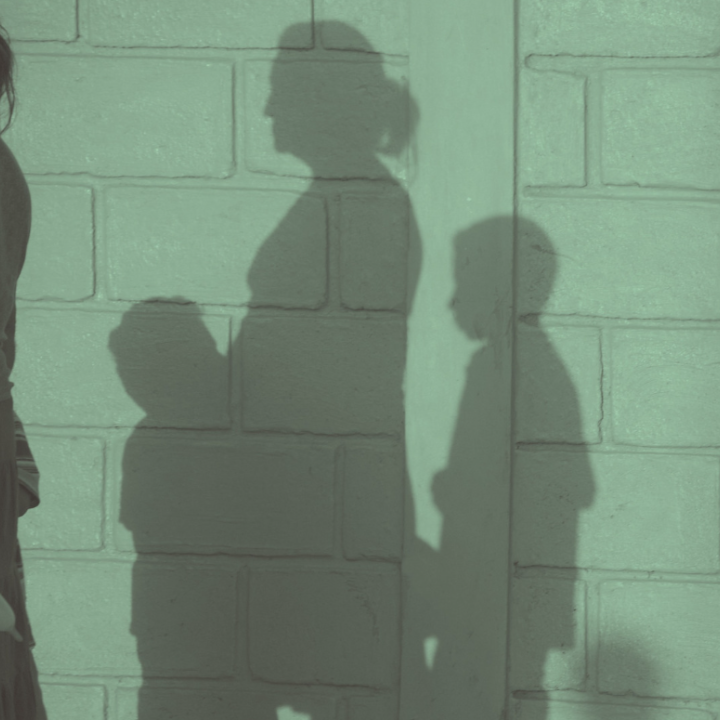 Shadow of mother and two children on a wall.