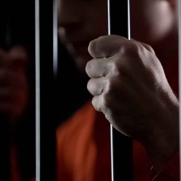 hands gripping prison bars