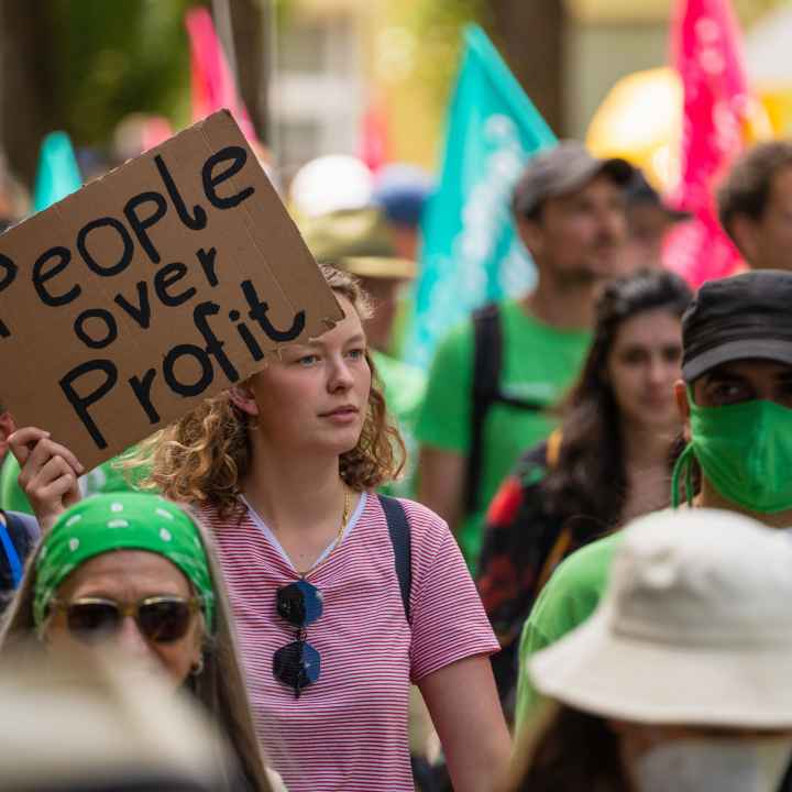 Protest sign that says "people over profit."