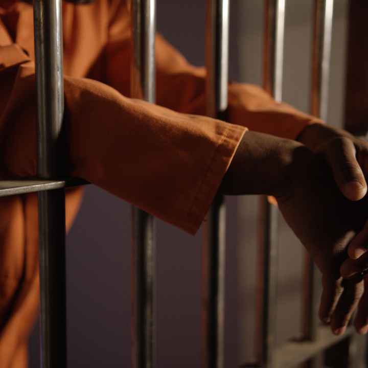 hands behing prison bars